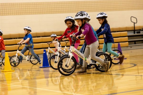 Kids riding bikes in gym class