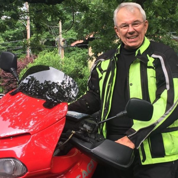 Bill Kniegge poses with a red motorcycle