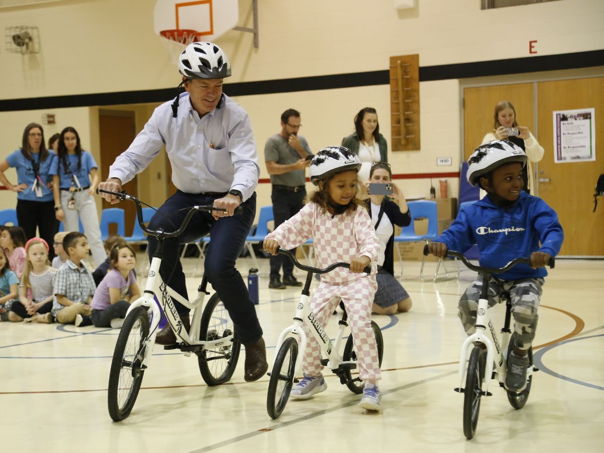 Nebraska Governor, Jim Pillen, riding a bike alongside kindergarten students