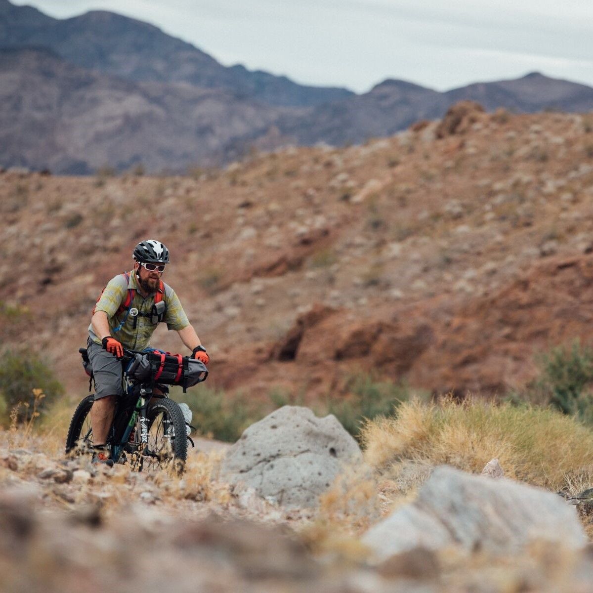 All Kids Bike ambassador Chad Pickard rides a mountain bike through a rugged mountainscape