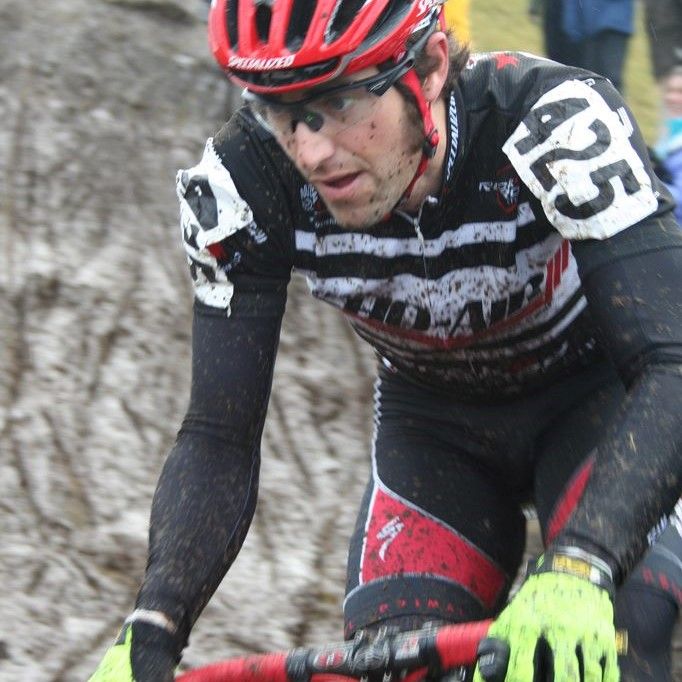 All Kids Bike amabassador Eric Bostrom in bike racing attire with a rock in the ackground