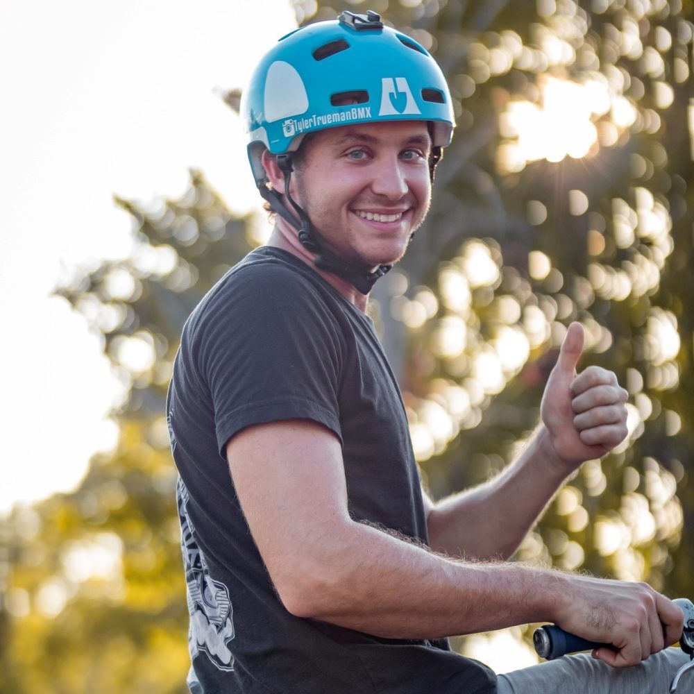 All Kids Bike ambassador Tyler Trueman, wearing a blue helmet and giving a thumbs up