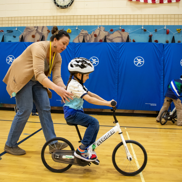 Student riding bike in kindergarten PE class