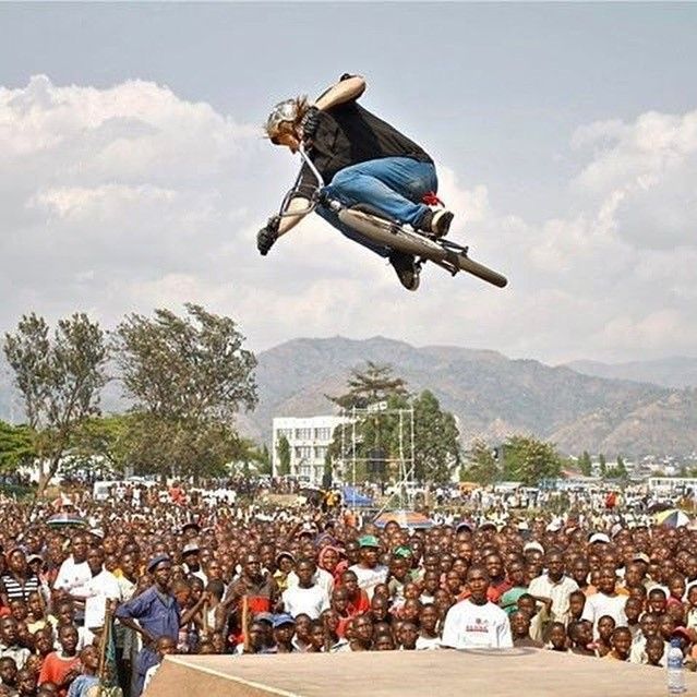 John Andrus jumping BMX bike in front of large crowd