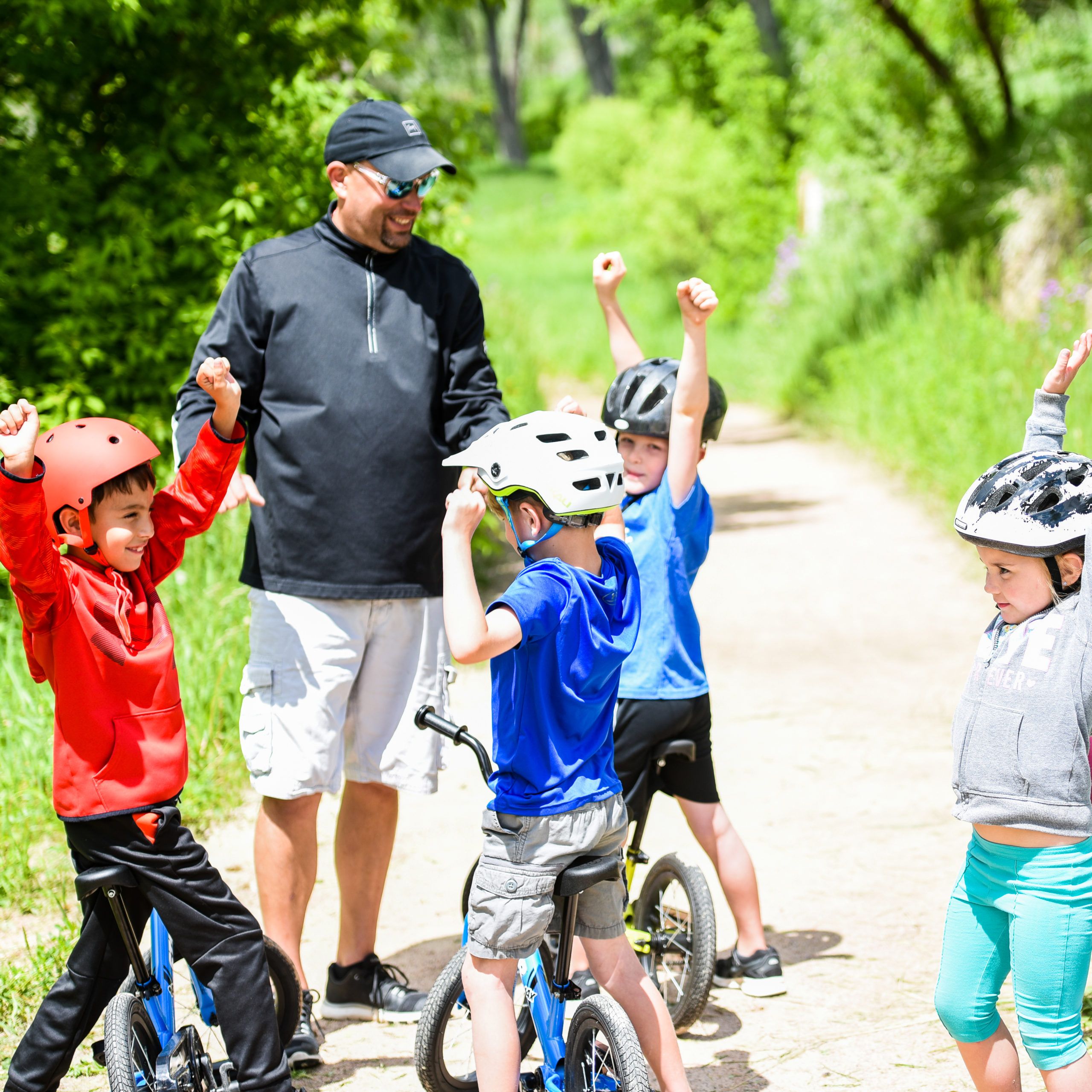 Kids cheering in a group on their bikes with their teacher