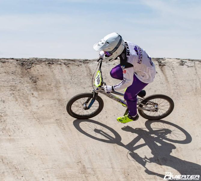 All Kids Bike ambassador Austin McKan riding a BMX bike along a concrete embankment