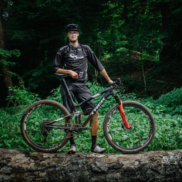 Jason Blodgett stops for a picture on a trail with his mountain bike.