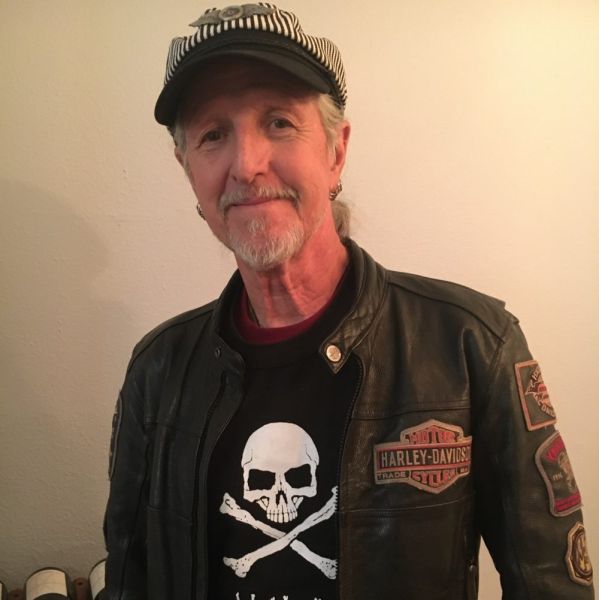 A portrait of All Kids Bike ambassador Patrick Simmons in a leather Harley Davidson jacket