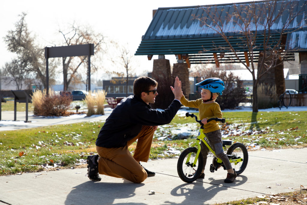 boy on bike giving dad high five