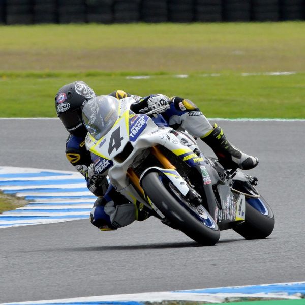 All Kids Bike ambassador Josh Hayes leaning into a turn during a motorcycle road race